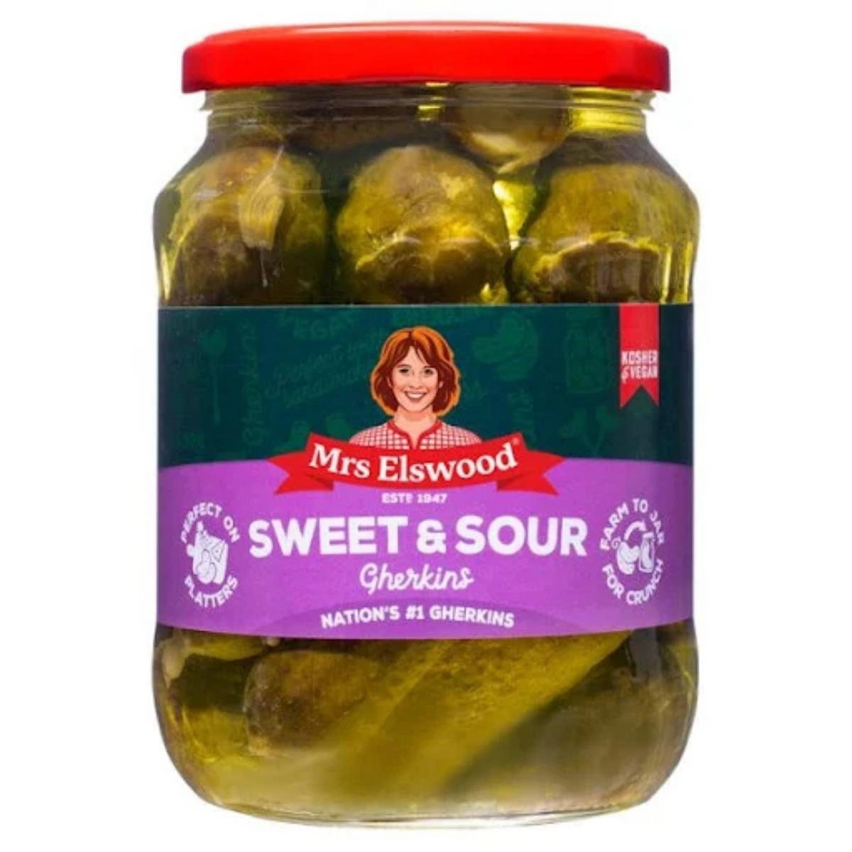A jar of Mrs Elswood Sweet Sour Cucumbers, which has a red lid and a purple label showcasing an illustration of a woman. A jar of Mrs Elswood Sweet Sour Cucumbers, which has a red lid and a purple label showcasing an illustration of a woman.