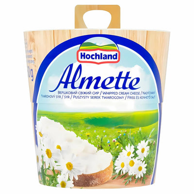 A 150g container of Almette Spreadable Full Fat Soft Cheese, with a label showing creamy cheese, daisies, and a green landscape.
