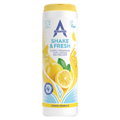 A white container of Astonish - Shake & Fresh Lemon Sparkle Carpet Freshener (350g), featuring images of lemons and yellow design elements on the label.