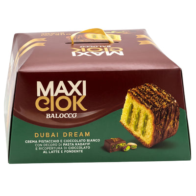 Balocco Maxi Ciok Dubai Dream Cake, a box of pistachio cream-filled kataifi pastry with chocolate coating and shredded topping, shown as a slice revealing the green filling next to pistachio chocolate.