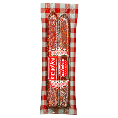 A vacuum-sealed package of Bella - Naroden Raw Dried Sushenitsa (180g), featuring two dried sausage sticks, red and white checkered background, and a Cyrillic label.