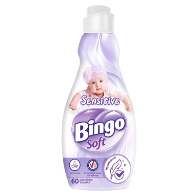 A 1440ml bottle of Bingo Soft - Sensitive Fabric Softener, designed for 60 washes, features branding with a baby in a purple outfit on the label and displays symbols and text that indicate it is hypoallergenic and concentrated.