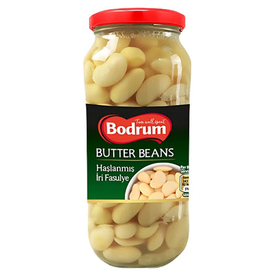 The 540g jar of Bodrum Butter Beans features a red lid and green label reading "Haslanmis Iri Fasulye." It contains large white beans in liquid, making them a nutrient-rich, flavourful addition to any dish.