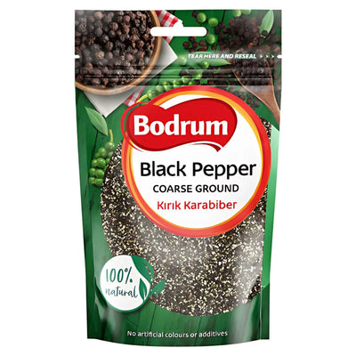 A 100g pack of Bodrum Black Pepper Coarse Ground, labeled “100% natural” with no artificial colors or additives, shown against a green backdrop with peppercorns.