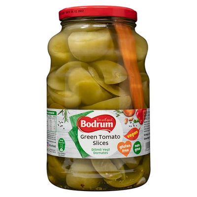 A 1600g jar of Bodrum Green Tomato Slices, known for its tangy flavor, carries labels that certify it as gluten-free, vegan, and non-GMO.