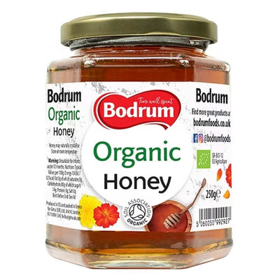 Bodrum - Organic Honey - 250g comes in a jar with a green and white label, featuring a honey dipper and flowers, offering the natural sweetness of organic honey.