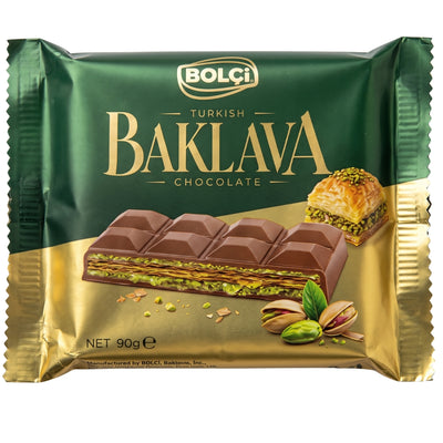 A Bolci - Turkish Baklava Chocolate Bar - 90g package showing layers of flaky pastry and pistachio, with a piece of baklava and shelled pistachios pictured below.