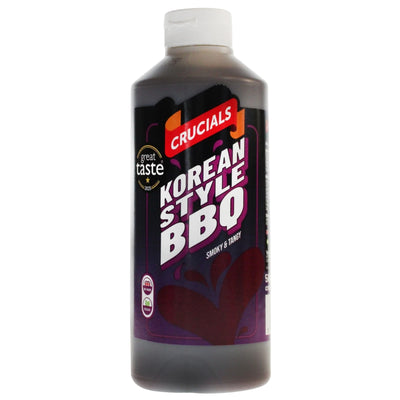 A 500ml bottle of Crucials Korean Style Smoky & Tangy BBQ Sauce, featuring a black and purple label and a white cap.
