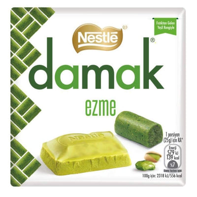 The Damak - Ezme Pistachio with White Chocolate Bar packaging highlights its Mediterranean appeal with green pistachios and enticing chocolate visuals. It includes calorie and nutritional info, offering an authentic taste inspired by a Turkish recipe.