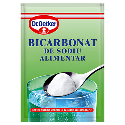 A green Dr.Oetker Bicarbonate Soda 50g pack is shown with a spoonful of white powder above a glass of water, highlighting this trusted baking essential on the packaging.