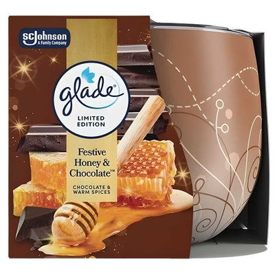 The Glade - Honey & Chocolate Scented Candle (108g) sits beside its packaging, featuring images of chocolate, honeycomb, and spices—ideal for adding a festive, decorative touch and a cozy aroma to your home.