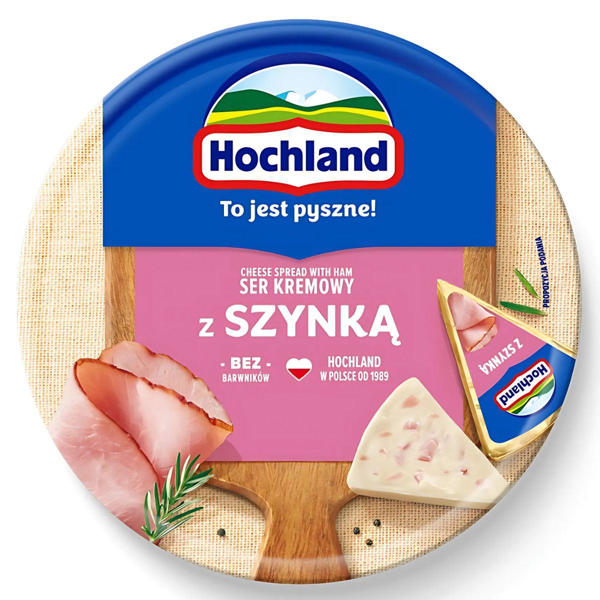 Hochland - Creamy Cheese with Ham - 180g comes in a round container with Polish labeling, featuring images of ham slices, cheese wedge, and rosemary on the lid—perfect for lovers of savory ham and creamy cheese flavor.