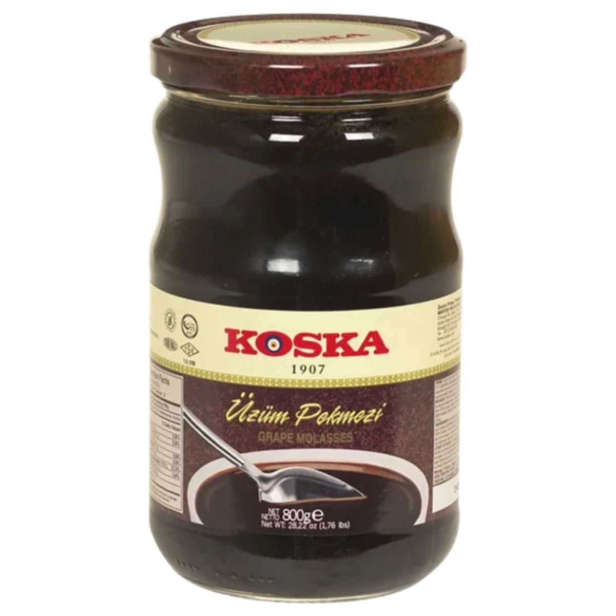An 800g glass jar of Koska Grape Molasses featuring a label with product details and an image of a spoon with molasses.