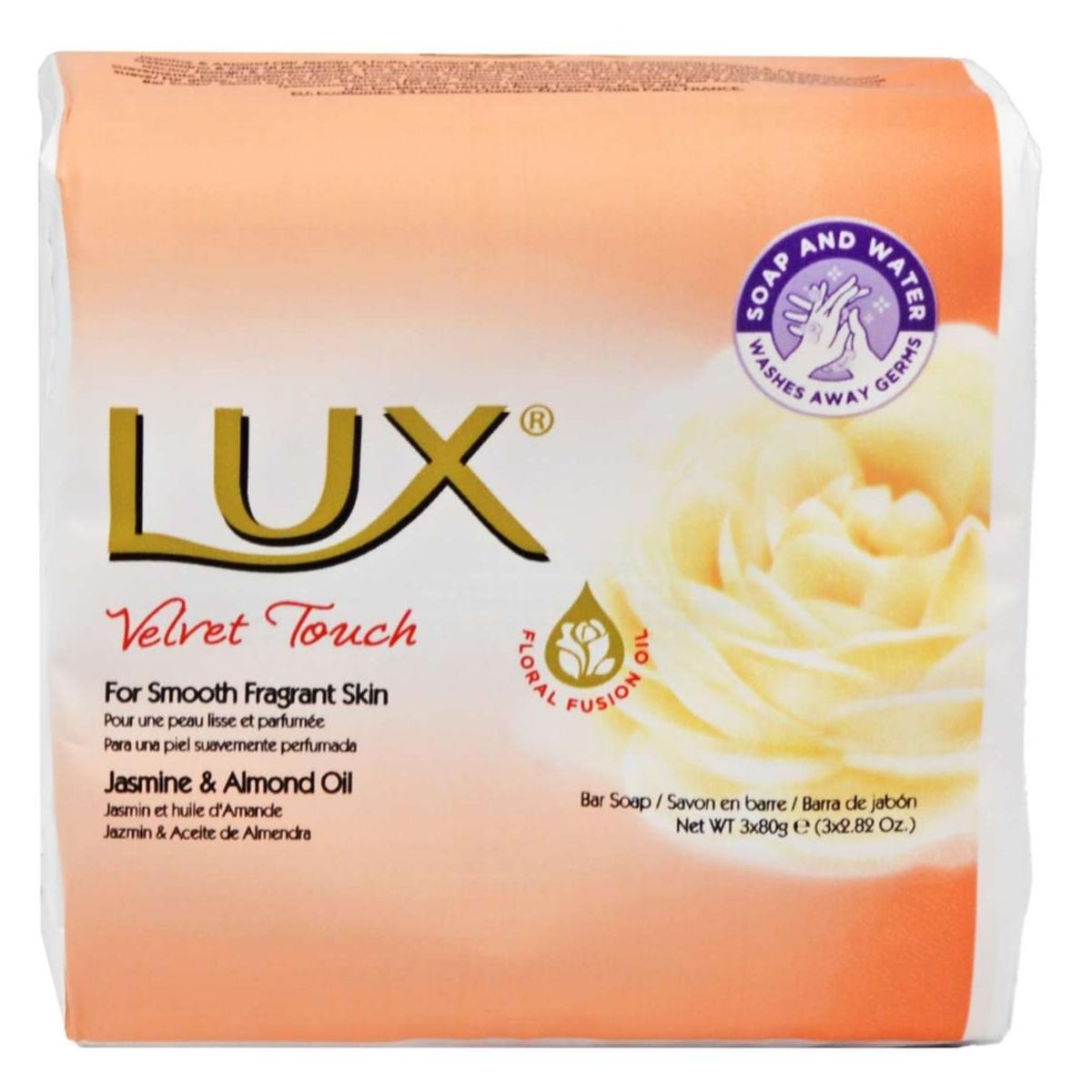 The Lux - Velvet Touch Soap, enriched with jasmine and almond oil for smooth, soft skin, features a floral design and promises luxurious lather with "smooth fragrant skin." Net weight: 80g. Packaging includes soap and water seal in the top right corner.