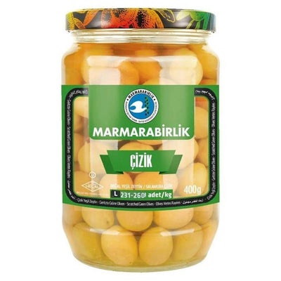 A 670g jar of Marmarabirlik Scratched and Pickled Green Olives, with a green and black label and whole green olives visible through the glass.