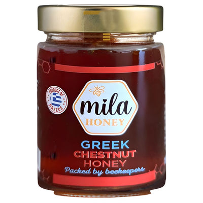 A 450g Mila Greek Chestnut Honey Jar with a gold lid, labeled “Packed by beekeepers” and a “Product of Greece” seal. This rich honey from Mila delivers exceptional Greek taste and quality.