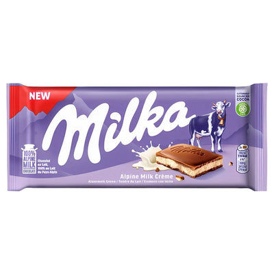 The Milka - Alpine Milk Creme Chocolate Bar (100g) features Milka’s signature purple packaging with a cow, milk splash, and chocolate piece on the front, showcasing its creamy texture and delicious taste.