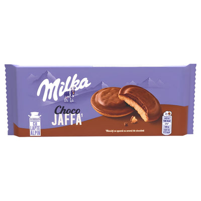 A pack of Milka - Choco Flavoured Jaffa (128g) biscuits, showing two chocolate mousse biscuits coated in Alpine milk chocolate—one partially eaten—set against a purple backdrop.