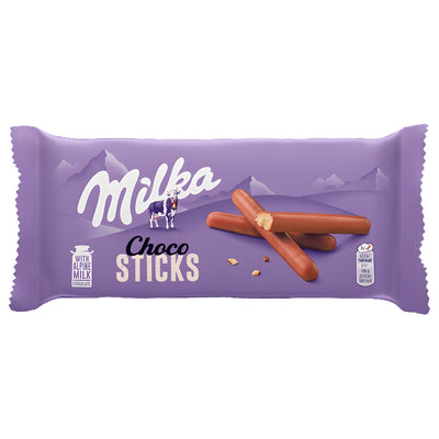 A 112g purple pack of Milka Choco Sticks shows milk chocolate biscuits with Alpine mountain graphics, emphasizing Milka’s signature Alpine milk.