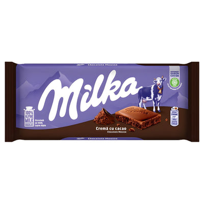 Milka’s 100g Chocolate With Cocoa Cream & Chocolate Mousse bar features purple packaging with a cow illustration and bold white "Milka" logo, combining creamy cocoa cream and chocolate mousse for a rich, indulgent taste.