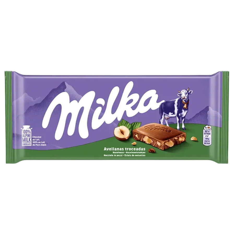 A Milka - Chocolate With Hazelnut Pieces - 90g bar with hazelnut pieces on purple and green packaging featuring a cow.