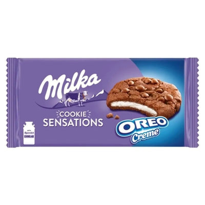 Milka - Chocolate Cookie Sensations with Oreo Cream (156g) showcases chocolate cookies filled with Oreo cream, displayed on a purple and blue background.