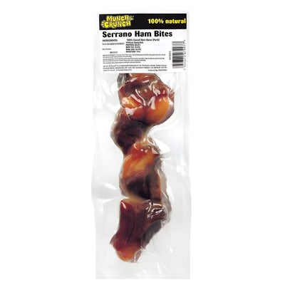 Vacuum-sealed Munch & Crunch Serrano Ham Bites for dogs, with visible pieces of premium cured ham and a clear top label. 1 piece per pack.