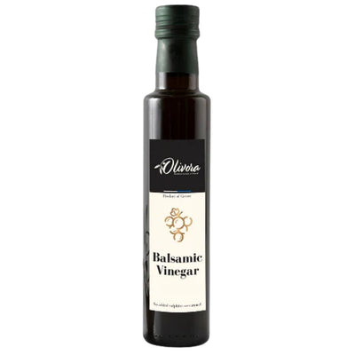 The Olivora Balsamic Vinegar (250ml) comes in a dark glass bottle with a black cap and gold-accented label, made from sun-dried grapes for a rich, authentic flavor.