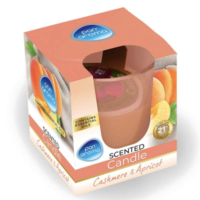 Pan Aroma's "Cashmere & Apricot" candle in a peach hue and apricot-adorned box features an essential oils symbol, offering a warm, inviting fragrance with a 21-hour burn time.