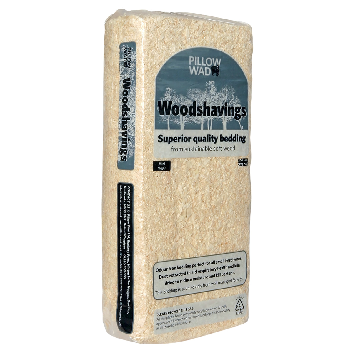 A clear plastic bag filled with wood shavings. The label reads "Pillow Wad - Woodshavings - 1Kg, Superior quality pet bedding from sustainable softwood.