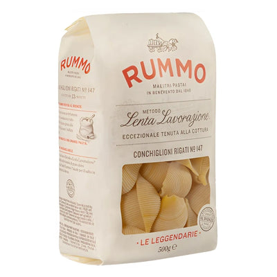 A 500g bag of Rummo Conchiglioni Rigati No.147 pasta from Rummo, featuring cream-colored packaging with red and black text and a clear window displaying the signature shell-shaped pasta inside.