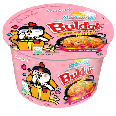 A pink cup of Samyang - Buldak Carbonara Hot Chicken Flavour Ramen (Halal) 105g, featuring cartoon chicken artwork on the packaging.