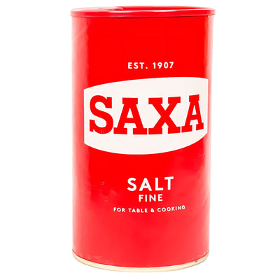 A 750g Saxa Fine Table Salt Drum, red and cylindrical, labeled for cooking and table use with "Est. 1907" at the top.