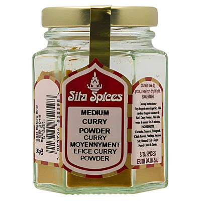 A glass jar of Sita Spices' Medium Curry Powder with a gold lid and a colorful label detailing ingredients and usage instructions, perfect for adding depth to your dishes.