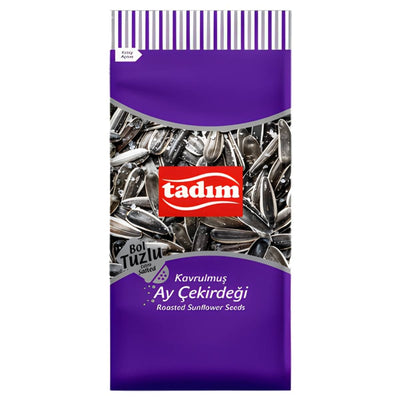 A purple and white Tadım package displays Extra Salted & Roasted Sunflower Seeds (150g), with sunflower seed images and product info in Turkish and English, highlighting classic Turkish-style snacks.