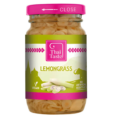 Thai Taste Lemongrass 114g comes in a glass jar with a pink lid and green label featuring lemongrass slices. This vegan product contains no artificial additives and is ideal for adding authentic Thai flavor to your dishes.