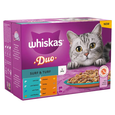 A purple box of Whiskas 1+ Duo Surf and Turf Adult Wet Cat Food Pouches in Jelly (12 x 85g) features a gray tabby cat, a food plate, and icons highlighting the range of tasty flavors on the packaging.