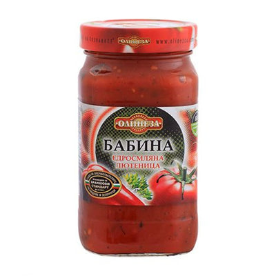 A 515g glass jar of Olinesa - Granny's Vegetable Lutenitsa Appetizer, a traditional Bulgarian spread, with a red lid and label featuring tomatoes and herbs.