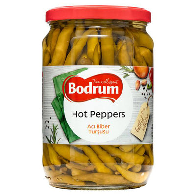 A 630g glass jar of Bodrum Pickled Hot Peppers with a red lid, filled with whole yellow-green peppers in brine. The label displays the Bodrum brand and product details in English and Turkish.