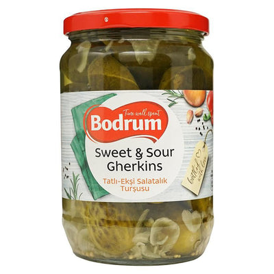 A 680g jar of Bodrum Sweet & Sour Gherkins with a red lid and label in English and Turkish, containing sliced gourmet pickles in a tangy sweet and sour brine.