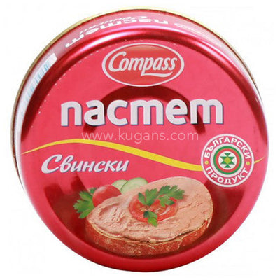 Compass Apetit Pork Pate (300g) comes in a round tin with Cyrillic text, showing pork pâté on bread with tomato, cucumber, and parsley—a savoury addition to any charcuterie board.